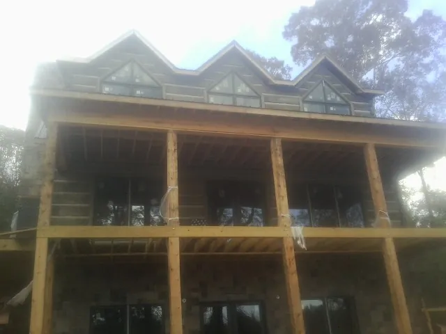 Dormers and porch framing on a large log home under construction — Roof Coating work by our crew in Pasco