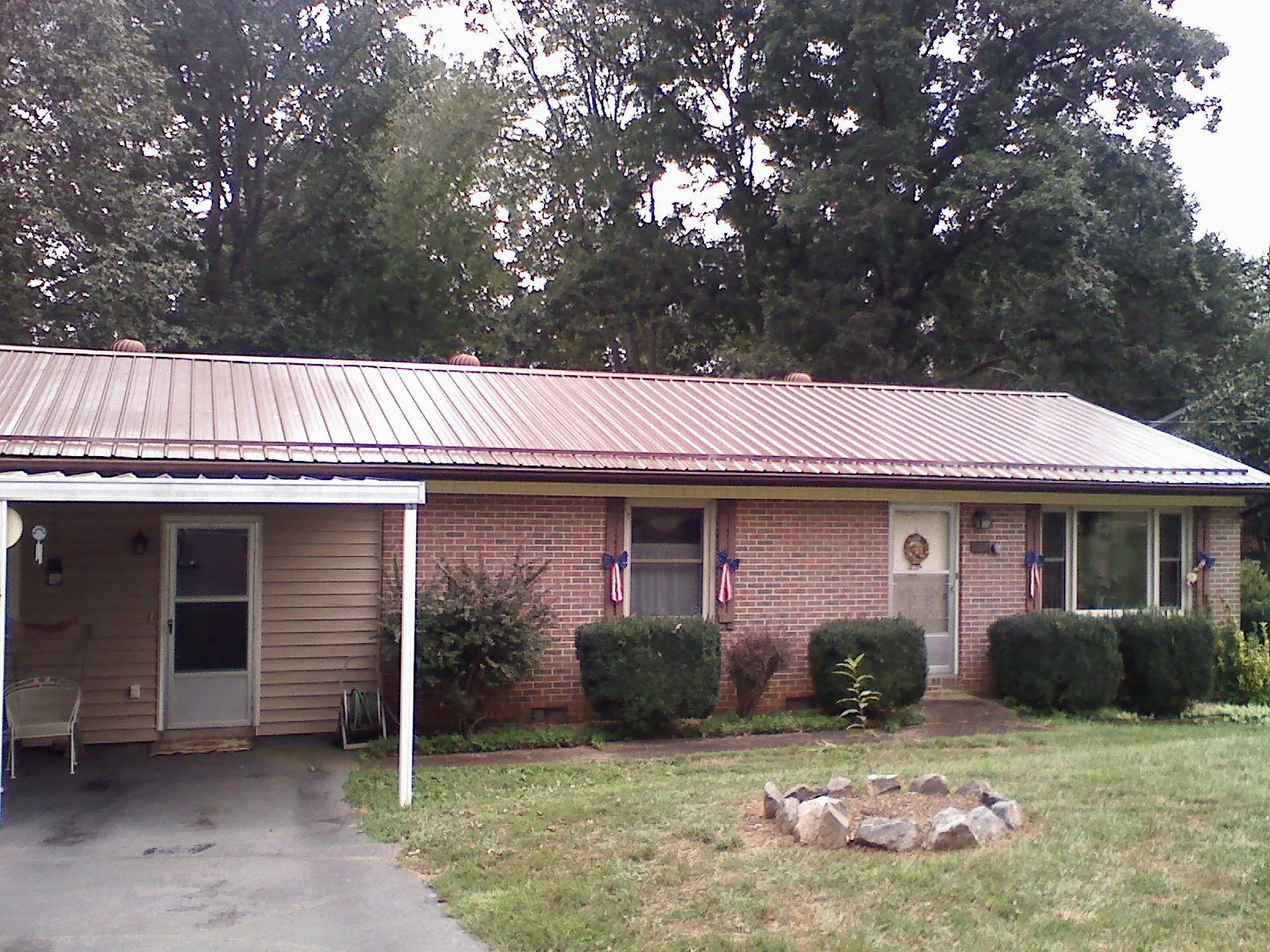 Bronze metal roof and carport on a brick ranch home — Roof Repair work by our crew in Pasco
